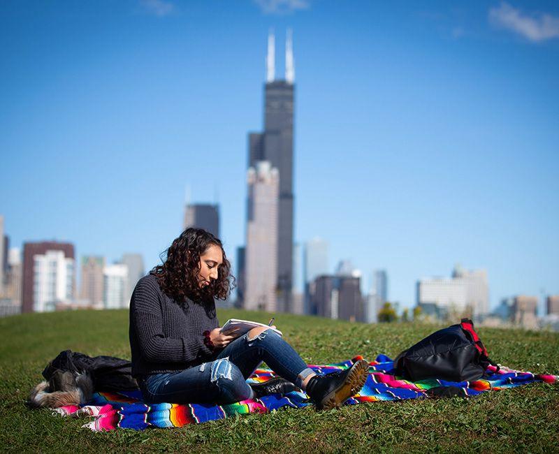 An Illinois Tech student reads at Tom Ping Park in Chicago near Mies Campus